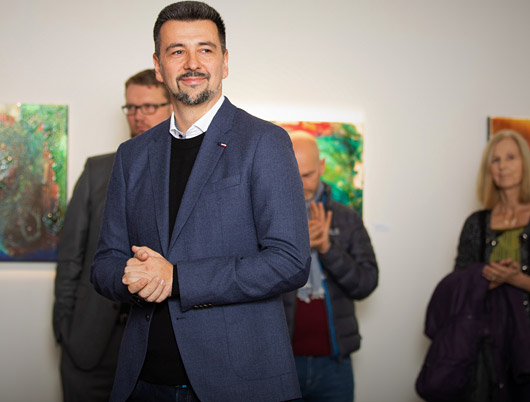 Der Maler und Diplom Designer Redzep Porovic erklärt den Gästen seine Werke